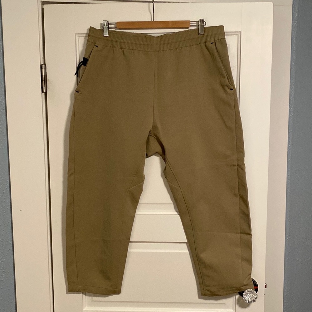 2 Nike Sportswear tech pants. 1 beige and 1 cool gray. Both are men’s X-LARGE.